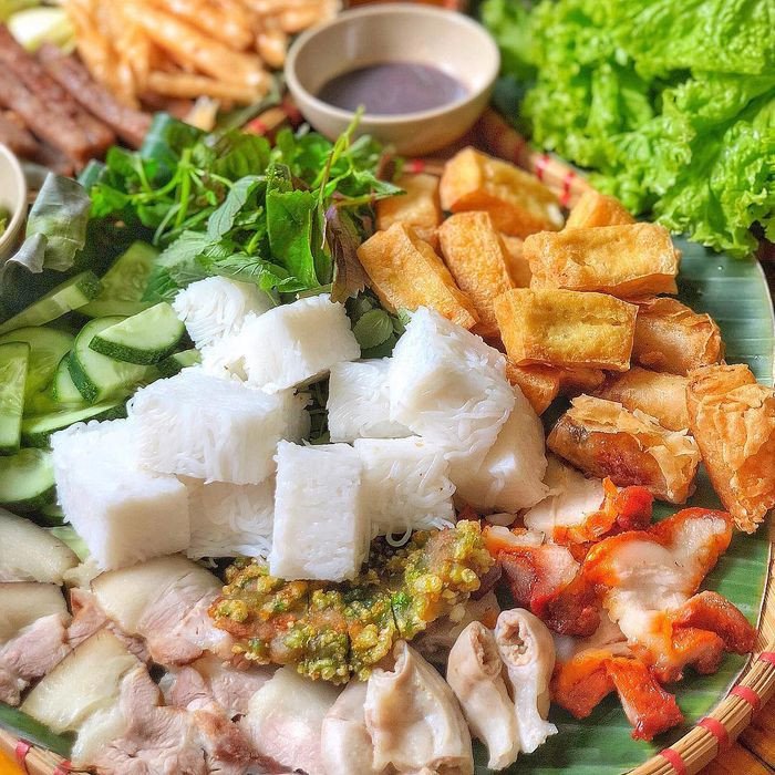 Bàn tay đang gắp đậu phụ nhúng mắm tôm