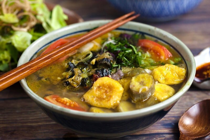 Chuẩn bị các nguyên liệu cơ bản cho món ăn, bao gồm ốc, đậu phụ rán và các loại rau thơm