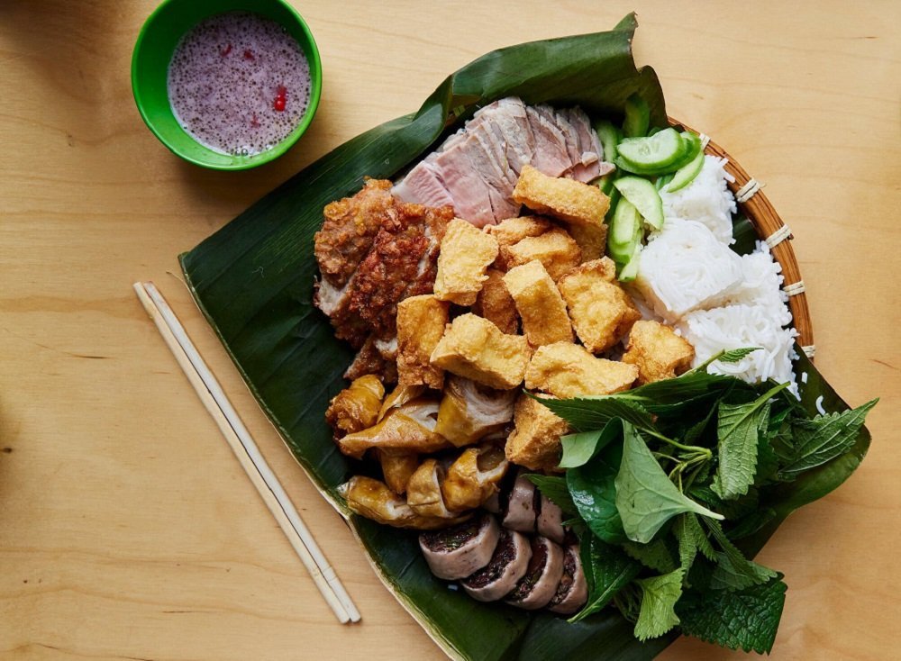 Đầu bếp đang tỉ mỉ pha chế chén mắm tôm với chanh và ớt