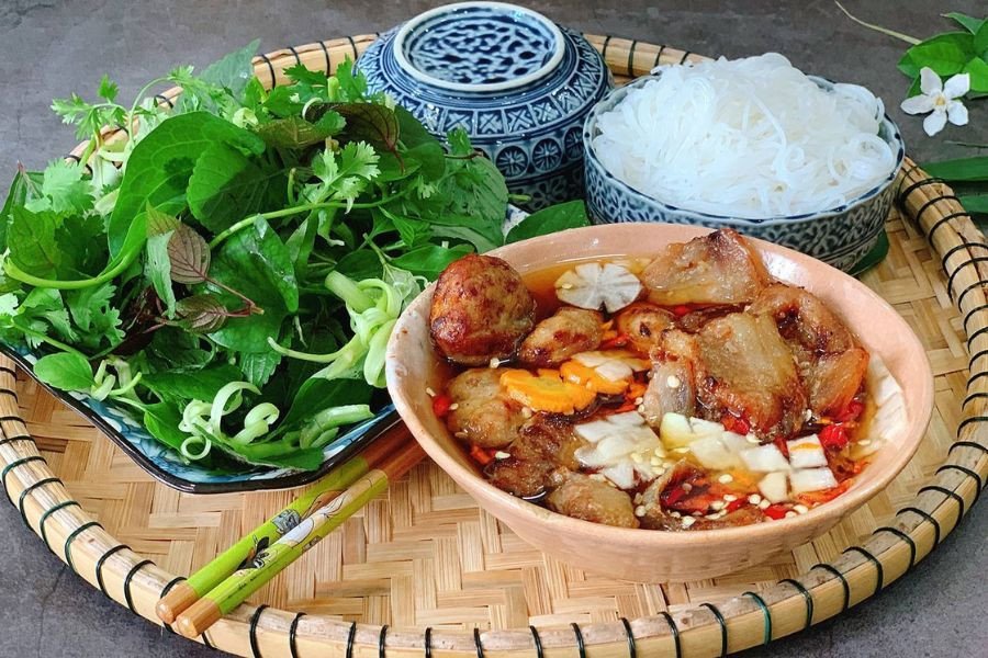 Đĩa bún tươi trắng ngần và rau sống xanh mướt đi kèm với bát nước chấm đặc trưng