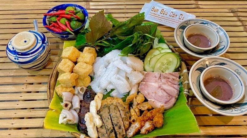 Hình ảnh các món ăn kèm như nem rán và chả cốm được bày biện đẹp mắt cạnh bún đậu