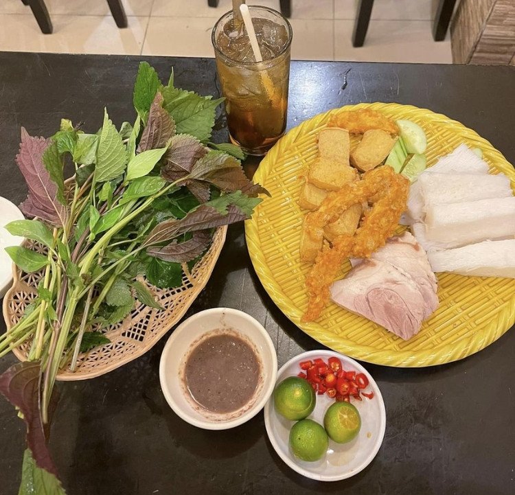 Hình ảnh cận cảnh một miếng đậu hũ chiên vàng ươm chuẩn bị được chấm vào mắm tôm