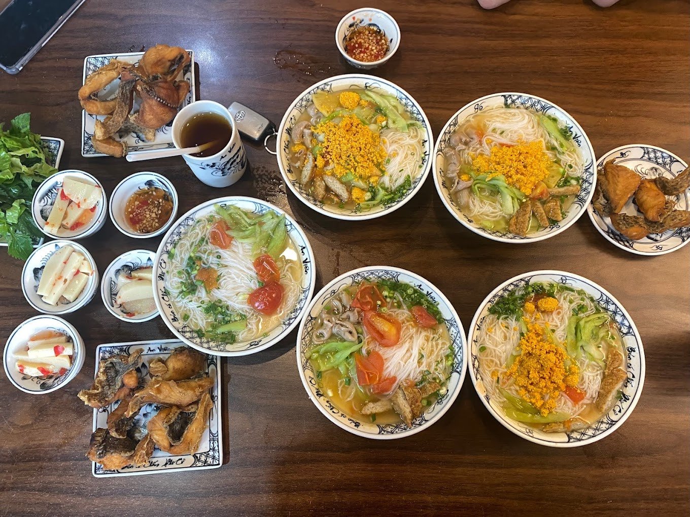 Hình ảnh một người đang thưởng thức món ăn với đôi đũa gắp đầy đủ các thành phần