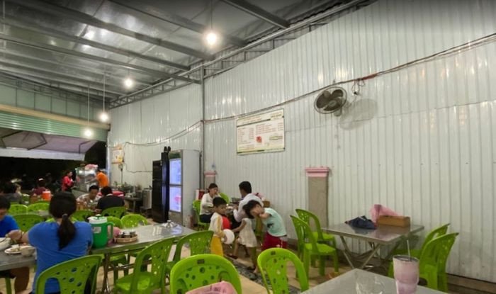 Hình ảnh người đang gắp bún và các loại rau vào nồi lẩu mắm đang sôi