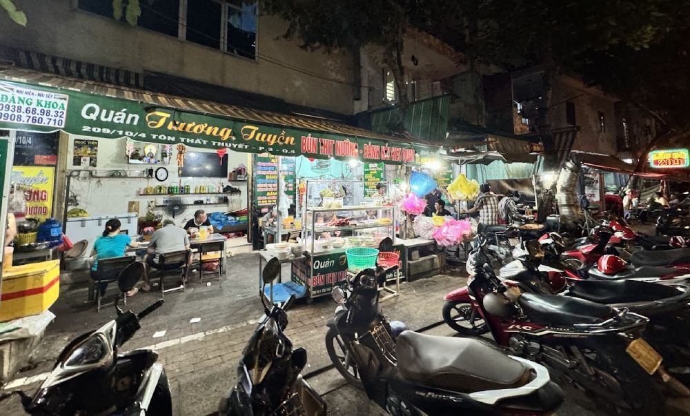 Không gian quán bún thịt nướng ven đường với tô bún đầy ắp topping