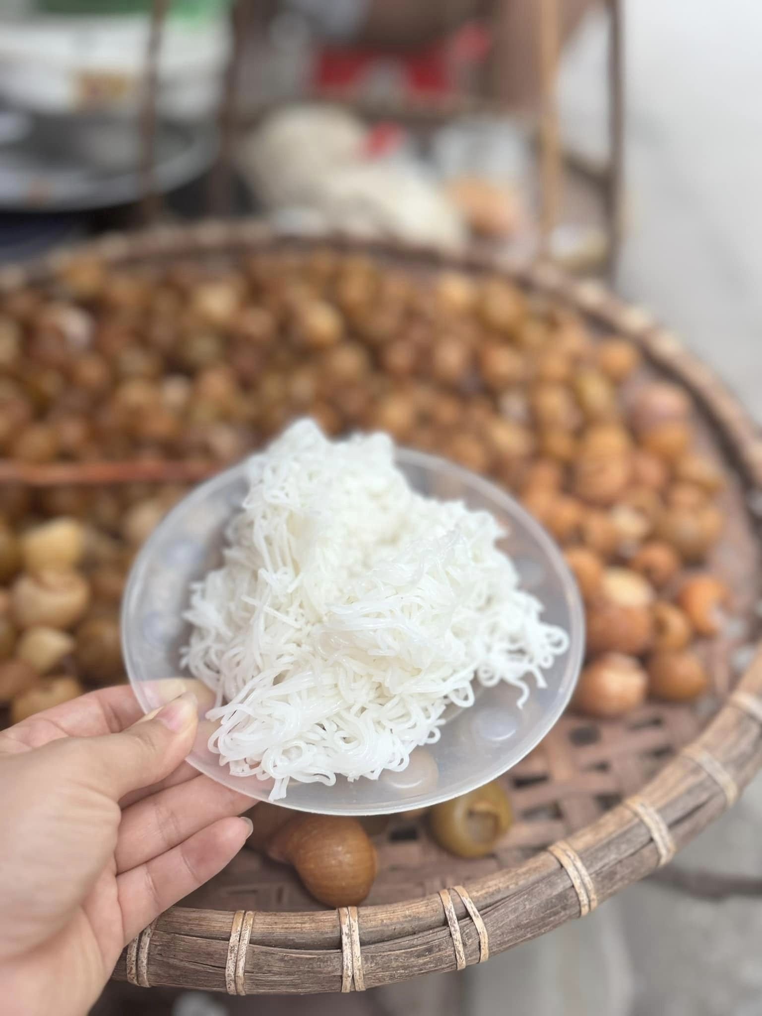 Một gánh bún ốc nguội được bày bán giản dị trên đôi quang gánh tre