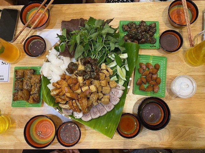 Một ly nước tắc hoặc trà giải khát được đặt cạnh mẹt bún đậu