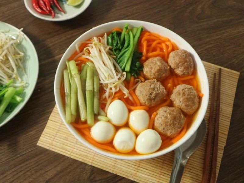Tô bún đỏ đầy đủ topping ăn kèm cùng rau xanh chần