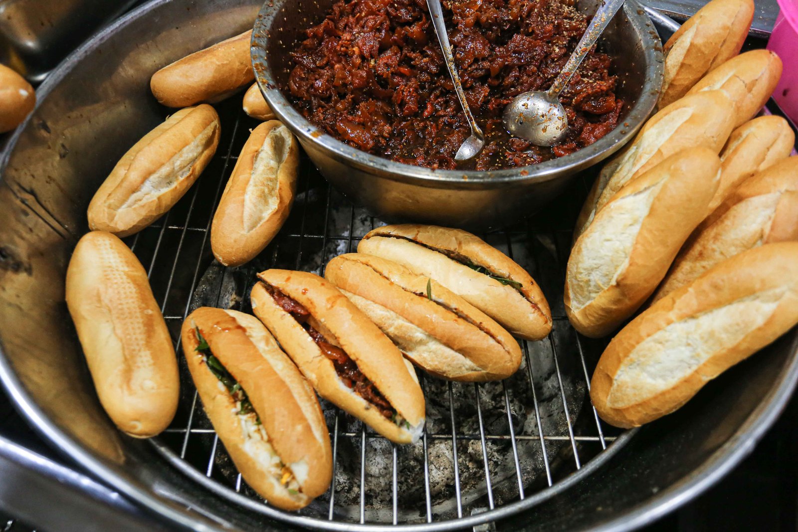 Bánh mì O Tho Trần Cao Vân đang được hơ nóng trên bếp than hồng, tỏa hương thơm lừng