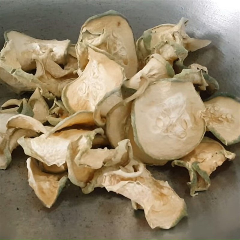 Bí đao khô đang được rang trên chảo với lửa nhỏ, tạo hương thơm đặc trưng cho trà bí đao hạt chia.