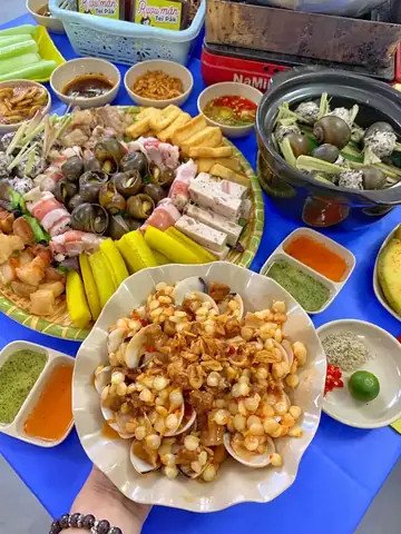 Cận cảnh một nồi lẩu ốc đang sôi sùng sục với nhiều loại hải sản và rau củ tươi ngon