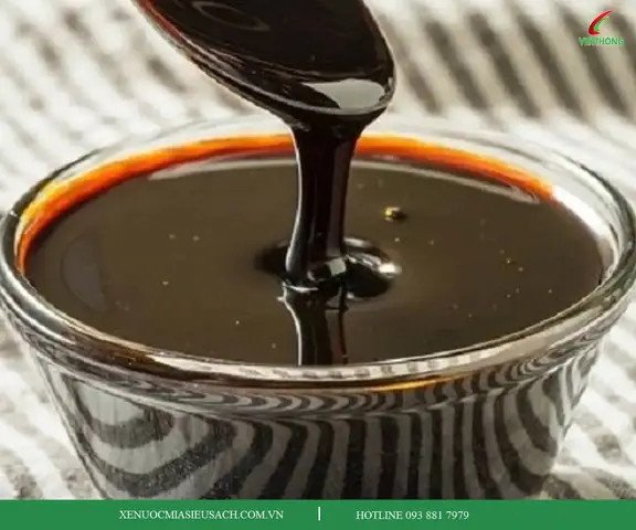 Cận cảnh nồi mật mía đang sôi trên bếp lửa, màu vàng óng ánh
