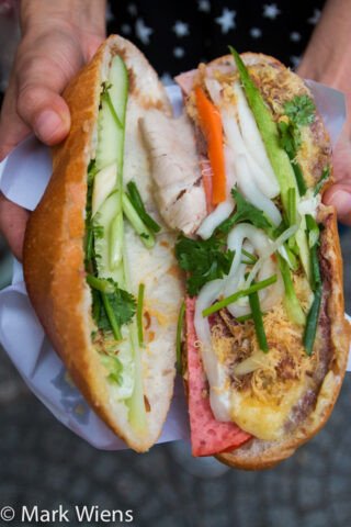 Chiếc bánh mì kẹp đầy đặn với đa dạng các loại nhân thịt nguội và pate tại Bánh Mì Huỳnh Hoa, biểu tượng ẩm thực Sài Gòn.