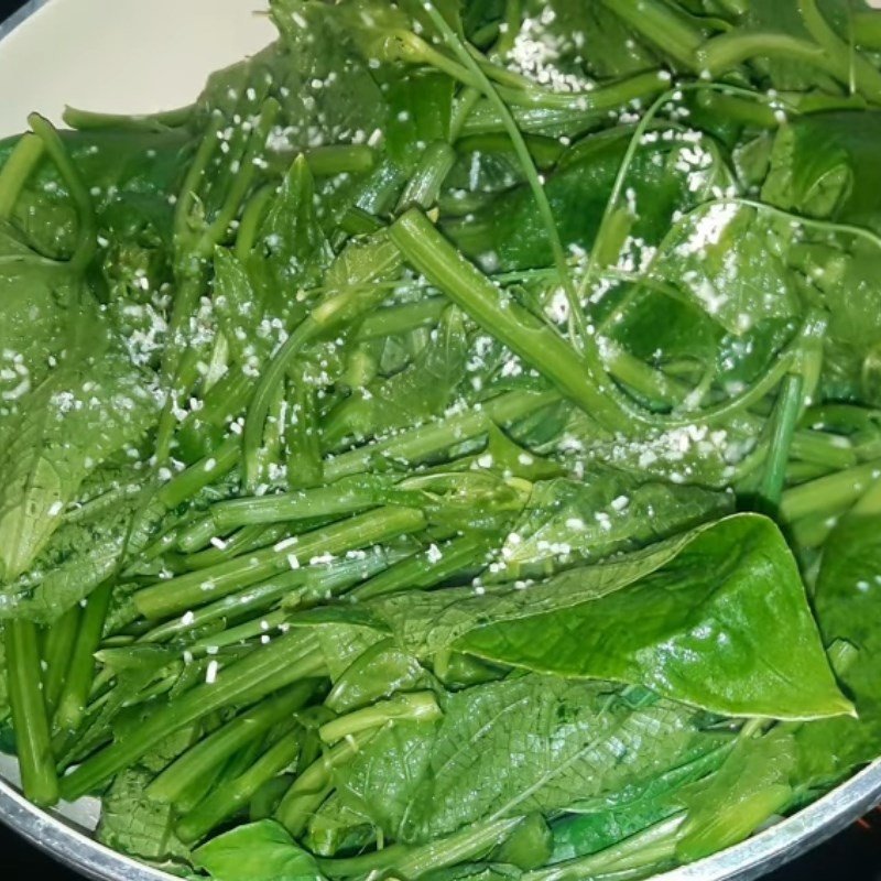 Đầu bếp đang đảo đều ngọn su su trên lửa lớn, đảm bảo rau chín tới và thấm gia vị