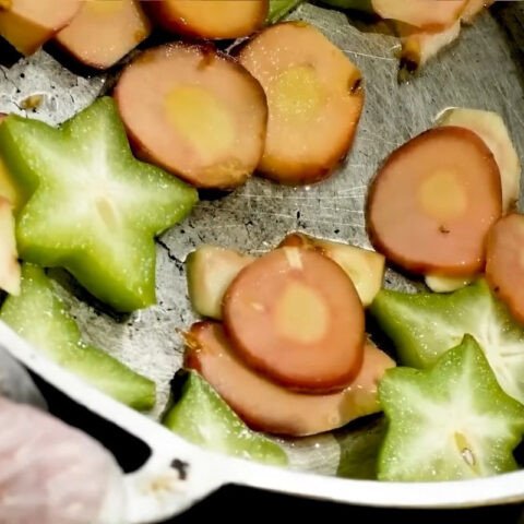 Lót riềng và thịt ba chỉ xuống đáy nồi để chuẩn bị kho cá
