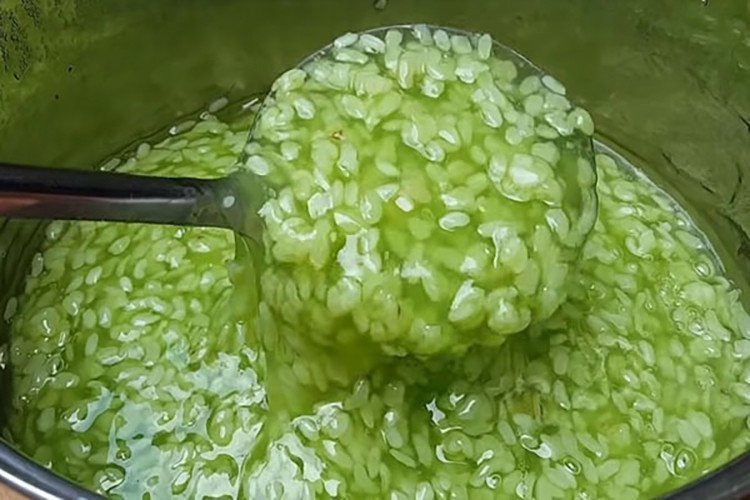 Mô tả hình ảnh nồi chè cốm khô đang được nấu trên bếp, với cốm nở đều và nước chè sánh mịn