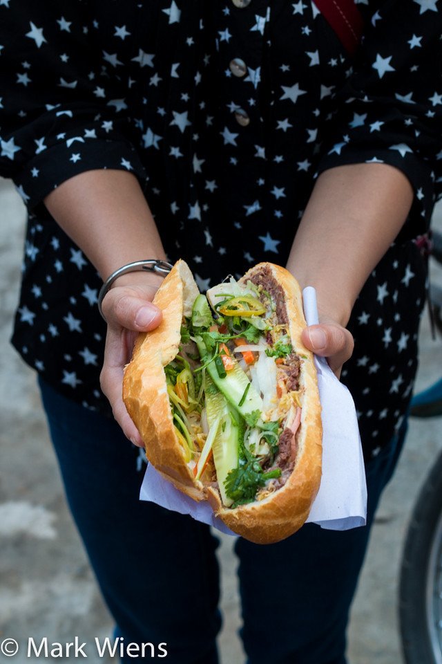 Một chiếc bánh mì Sài Gòn giòn tan với đầy đủ rau thơm và nhân, món ăn đường phố không thể bỏ lỡ.