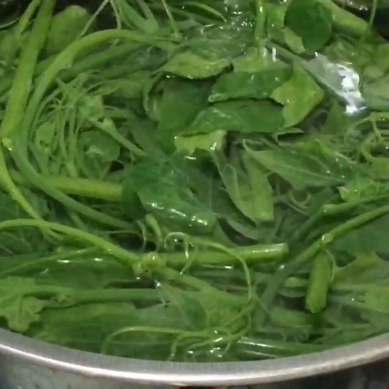 Ngọn su su đang được trụng nhanh trong nồi nước sôi, giữ độ xanh và giòn