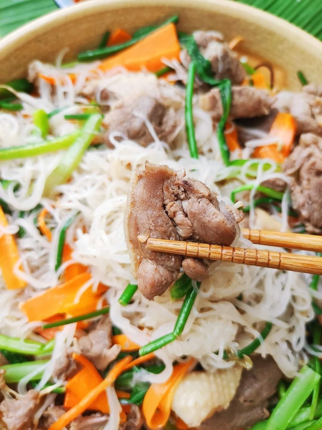 Thịt vịt và rau củ đang được xào trên chảo cho món hủ tiếu xào ngon
