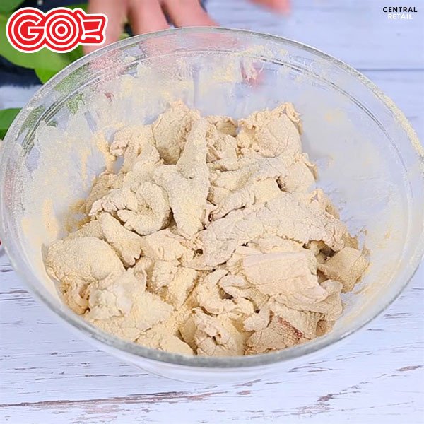 Trộn đều thịt heo với thính và gia vị là bước quan trọng tạo nên hương vị thịt chua.