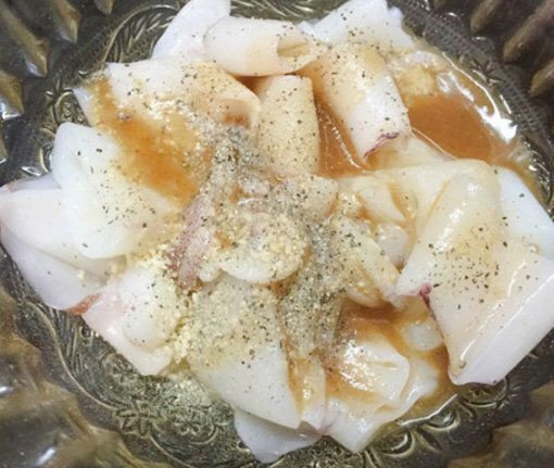 Ướp mực tươi với gia vị để thấm đều trước khi xào