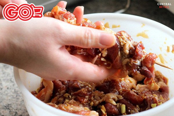 Xiên thịt heo đã ướp gia vị vào que tre